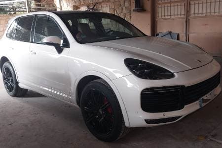 Luxury Taxi Porsche Cayenne parked in parking lot of residential area